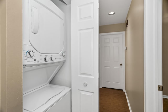 washroom with stacked washer and clothes dryer, dark wood-style floors, baseboards, and recessed lighting