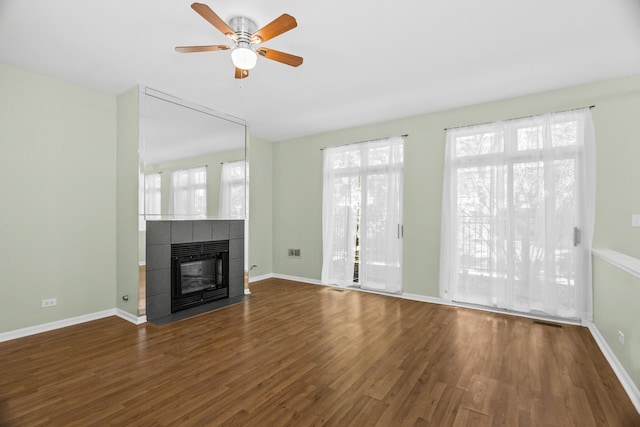 unfurnished living room featuring wood finished floors, healthy amount of natural light, and a ceiling fan