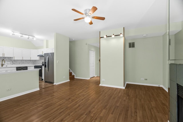 unfurnished living room with a ceiling fan, a sink, dark wood-style floors, stairway, and a tile fireplace