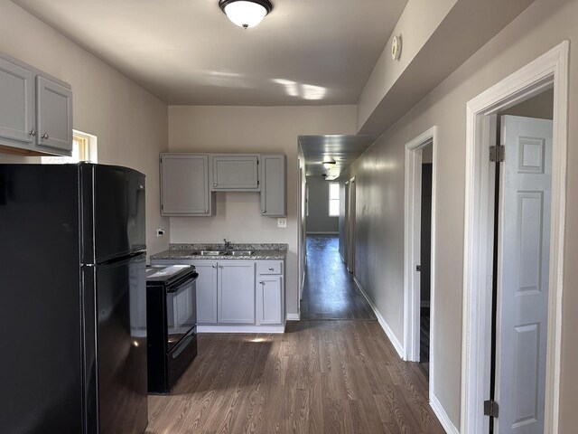 4107 W 16th St, Chicago, IL 60623 - kitchen featuring black appliances, a sink, dark wood finished floors, baseboards, and gray cabinetry