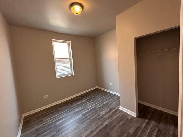 4107 W 16th St, Chicago, IL 60623 - unfurnished bedroom featuring dark wood-style flooring, a closet, and baseboards