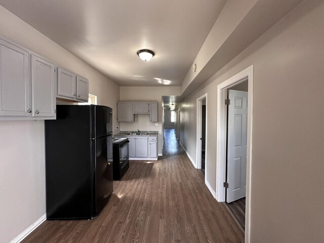 4107 W 16th St, Chicago, IL 60623 - kitchen with black appliances, dark wood-type flooring, baseboards, and a sink