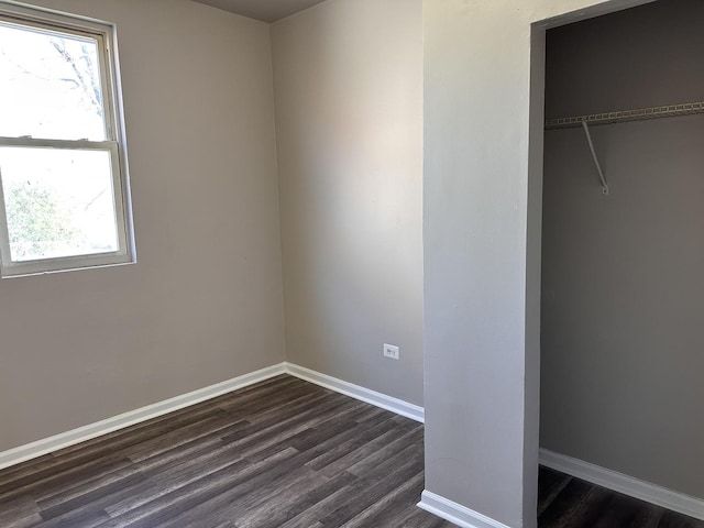 4107 W 16th St, Chicago, IL 60623 - unfurnished bedroom with dark wood-type flooring, multiple windows, baseboards, and a closet