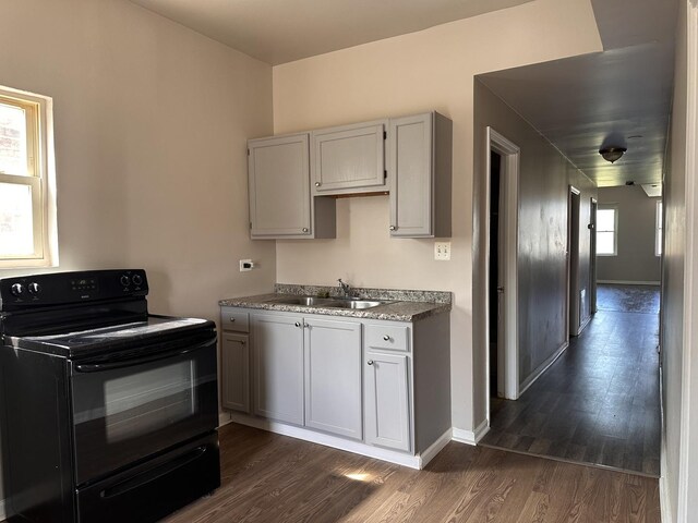 4107 W 16th St, Chicago, IL 60623 - kitchen with black range with electric stovetop, a sink, dark wood finished floors, and baseboards