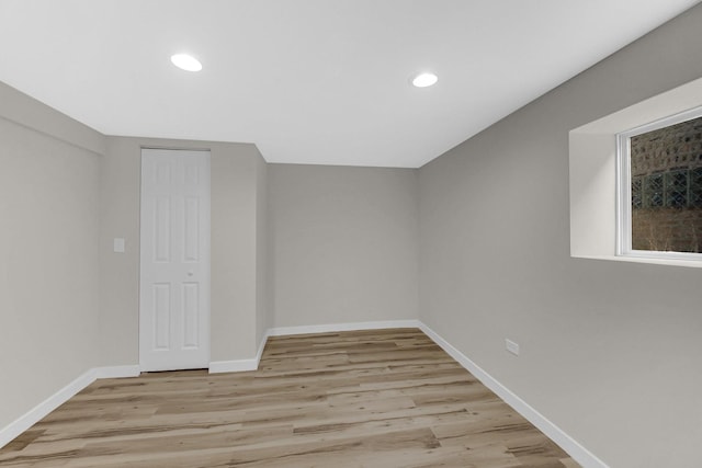 unfurnished room with light wood finished floors, baseboards, and recessed lighting