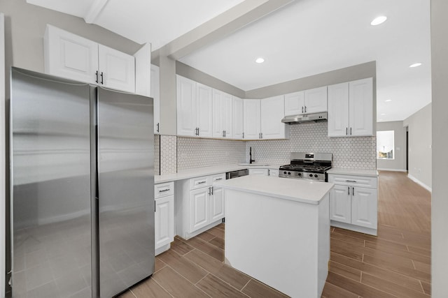 kitchen with white cabinets, light countertops, appliances with stainless steel finishes, and under cabinet range hood