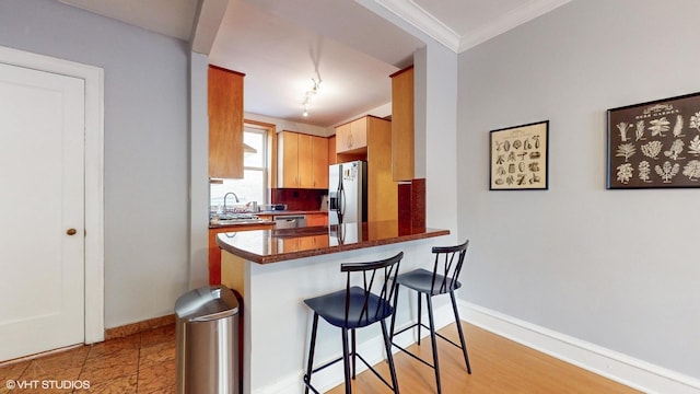 2335 N Commonwealth Ave Unit 2G, Chicago, IL 60614 - kitchen featuring a kitchen breakfast bar, appliances with stainless steel finishes, baseboards, and a sink