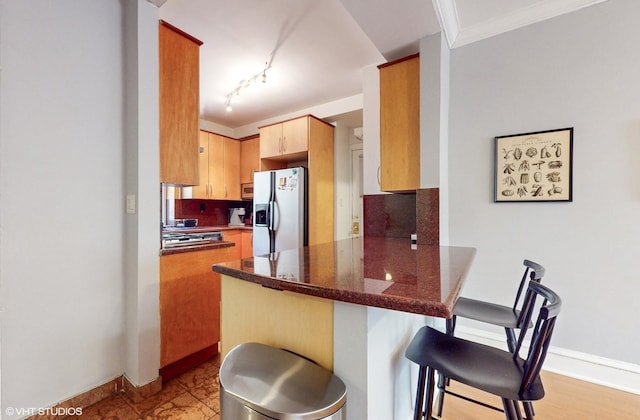 2335 N Commonwealth Ave Unit 2G, Chicago, IL 60614 - kitchen with stainless steel microwave, a peninsula, white fridge with ice dispenser, tasteful backsplash, and a breakfast bar area