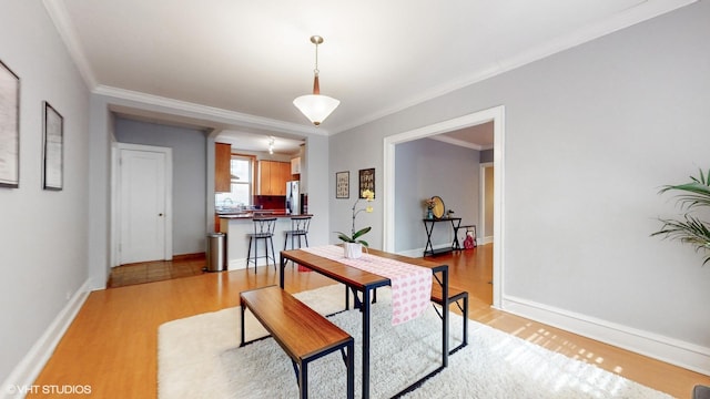 2335 N Commonwealth Ave Unit 2G, Chicago, IL 60614 - dining area with baseboards, crown molding, and light wood-style flooring