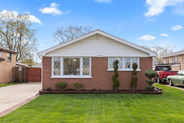 bungalow with brick siding, fence, and a front yard