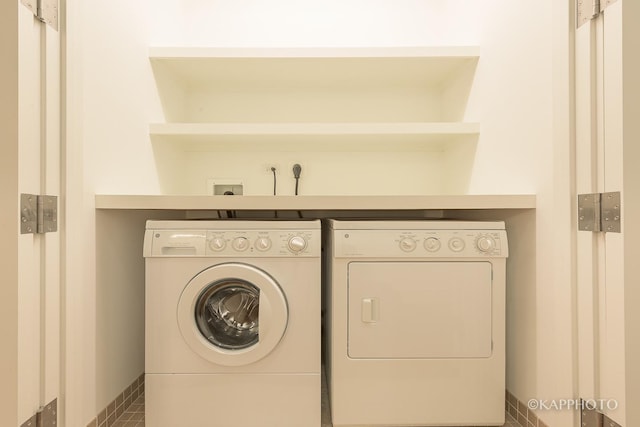 clothes washing area featuring independent washer and dryer, laundry area, and baseboards