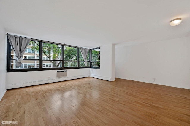 33 E Cedar St Unit 3H, Chicago, IL 60611 - unfurnished room with wood finished floors, a baseboard radiator, and a wall unit AC