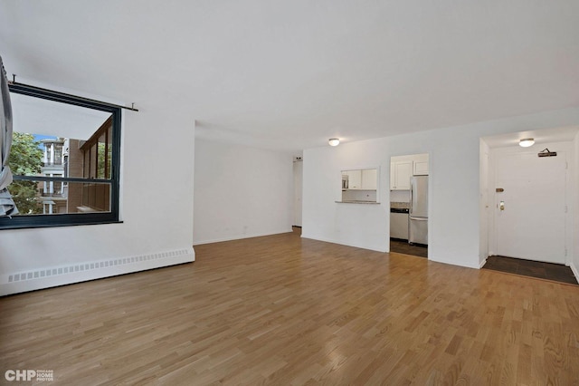 33 E Cedar St Unit 3H, Chicago, IL 60611 - unfurnished living room with a baseboard radiator and light wood-style flooring