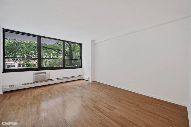 33 E Cedar St Unit 3H, Chicago, IL 60611 - unfurnished room featuring wood finished floors, a baseboard radiator, and an AC wall unit