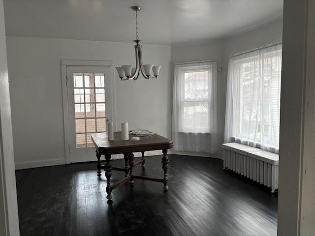 dining room with baseboards, dark wood-style floors, a notable chandelier, and radiator