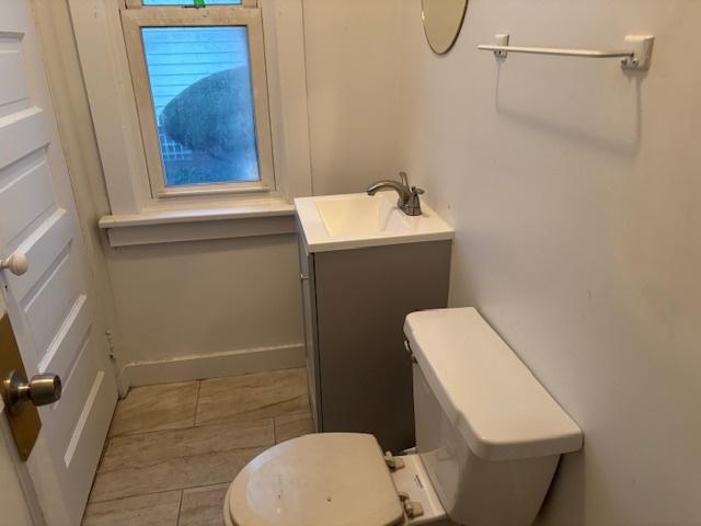 bathroom with baseboards, vanity, tile patterned flooring, and toilet