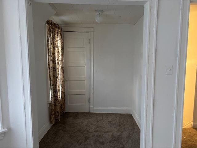 corridor featuring carpet flooring and baseboards