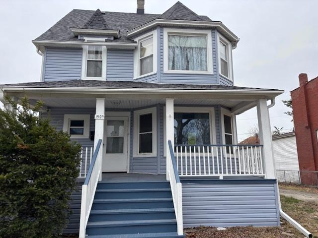 victorian home featuring a porch and a shingled roof