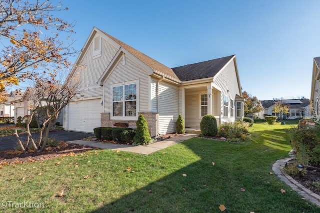 view of front facade with aphalt driveway, a garage, a front yard, brick siding, and a shingled roof