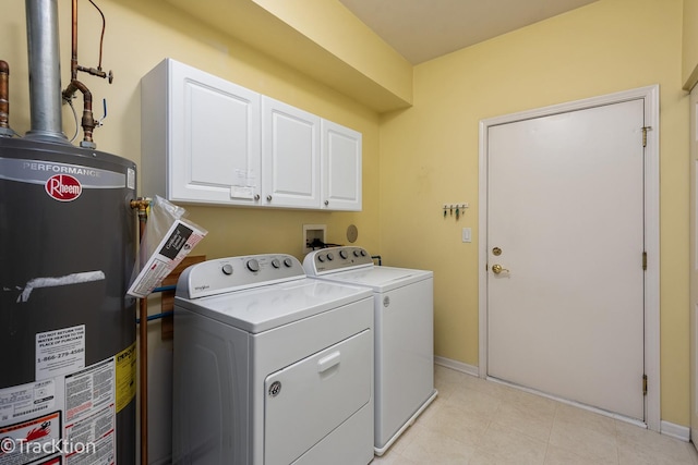 laundry room featuring baseboards, washing machine and clothes dryer, gas water heater, and cabinet space
