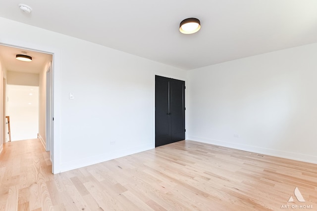 spare room featuring light wood finished floors and baseboards