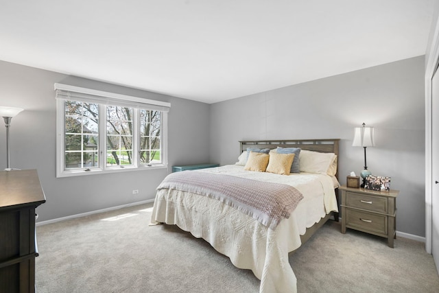 bedroom with baseboards and light colored carpet