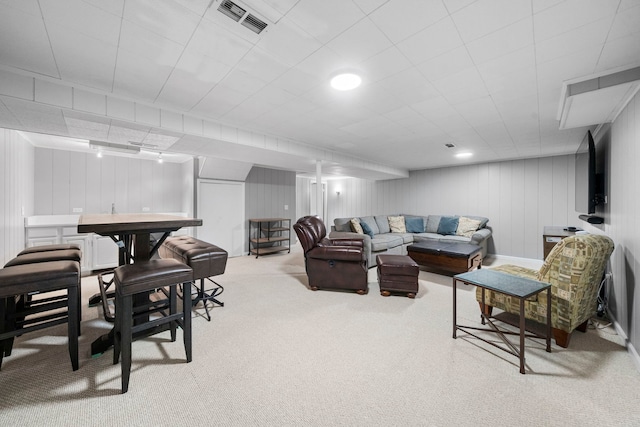 living area with carpet floors, bar, and visible vents
