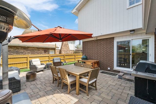 view of patio / terrace featuring fence, outdoor dining space, and an outdoor fire pit
