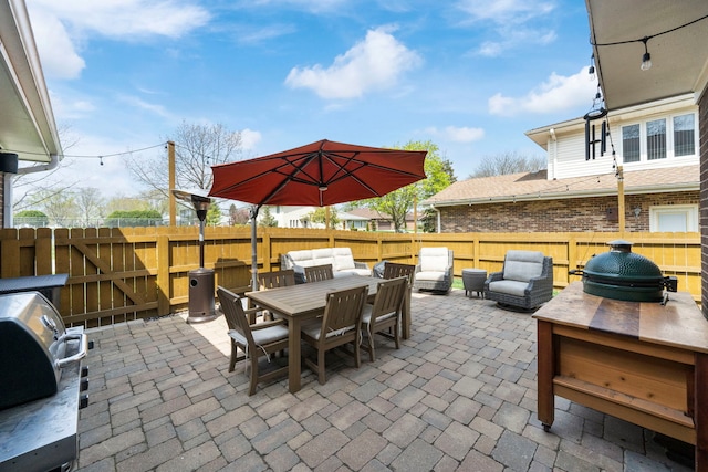 view of patio with grilling area, outdoor lounge area, outdoor dining area, and a fenced backyard