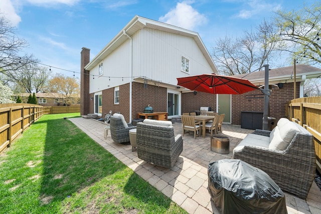 back of property with a lawn, a patio, an outdoor living space, and a fenced backyard