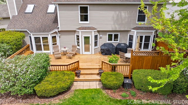 back of property with a deck and a shingled roof