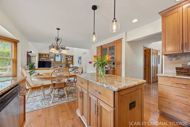 kitchen featuring light stone counters, backsplash, light wood finished floors, and dishwasher