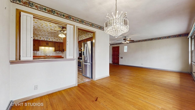 8743 Kedvale Ave, Skokie, IL 60076 - unfurnished room with baseboards, a baseboard radiator, ceiling fan with notable chandelier, and light wood-type flooring