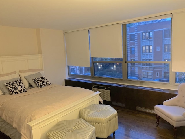 bedroom with wood finished floors and a wall mounted air conditioner