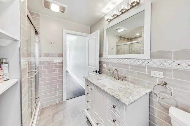 5801 N Drake Ave, Chicago, IL 60659 - full bath with vanity, tile patterned floors, toilet, a shower stall, and tile walls