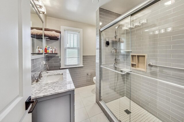 5801 N Drake Ave, Chicago, IL 60659 - full bath with tile patterned floors, vanity, a stall shower, and tile walls