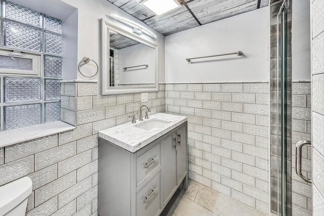 5801 N Drake Ave, Chicago, IL 60659 - full bathroom with tile patterned floors, tile walls, a shower stall, and vanity