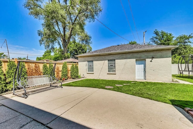 5801 N Drake Ave, Chicago, IL 60659 - back of property with a lawn, a patio area, fence, brick siding, and a trampoline