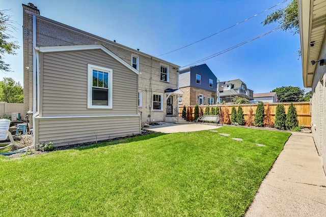 5801 N Drake Ave, Chicago, IL 60659 - rear view of property with a chimney, a patio area, fence, and a lawn