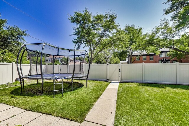 5801 N Drake Ave, Chicago, IL 60659 - view of home's community with a trampoline, a fenced backyard, a yard, and a gate