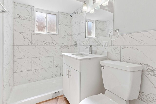 bathroom with toilet, tile walls, a shower stall, and plenty of natural light
