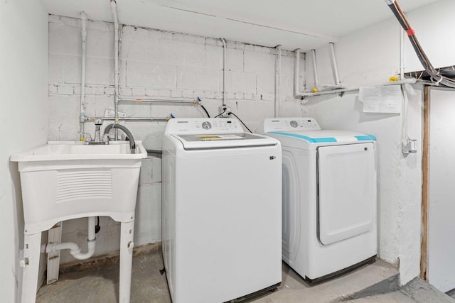 laundry room featuring concrete block wall, laundry area, and independent washer and dryer
