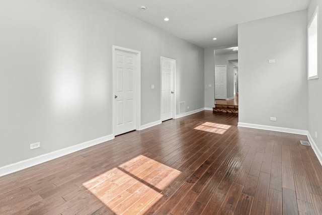 spare room featuring recessed lighting, visible vents, dark wood-style flooring, and baseboards