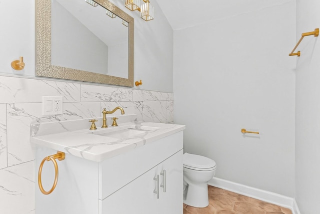half bathroom with vanity, toilet, and tile walls