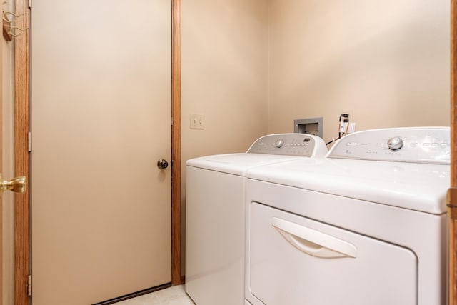washroom with light tile patterned floors, laundry area, and washer and clothes dryer