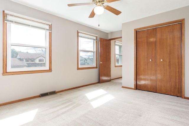 unfurnished bedroom featuring baseboards, carpet floors, visible vents, and a closet