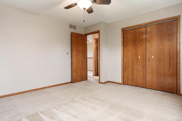 unfurnished bedroom featuring visible vents, light carpet, a closet, baseboards, and ceiling fan