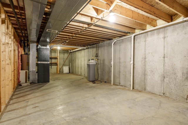 unfinished basement featuring heating unit, visible vents, and gas water heater