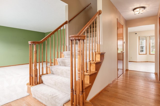 staircase with baseboards and wood finished floors