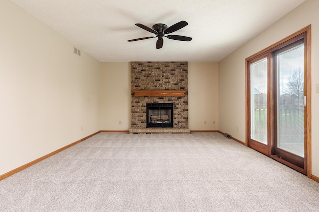 unfurnished living room featuring light carpet, baseboards, visible vents, a brick fireplace, and ceiling fan